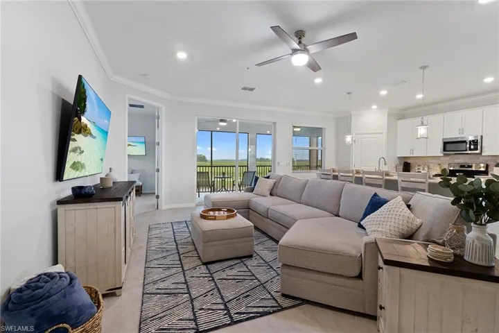 Living room featuring ornamental molding and ceiling fan