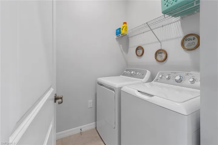 Laundry area with washer and dryer and light tile floors