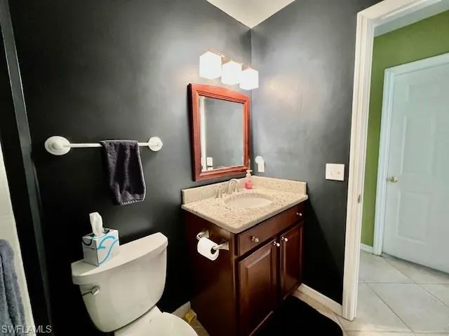 Bathroom featuring vanity, tile patterned flooring, and toilet