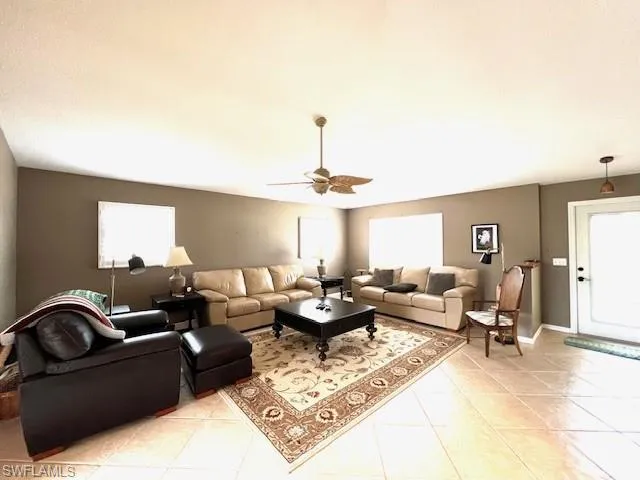 Living room with ceiling fan and light tile patterned floors