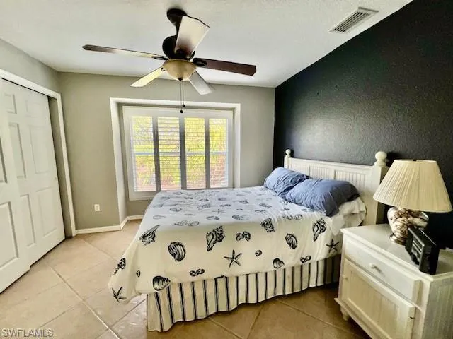 Tiled bedroom featuring a closet and ceiling fan