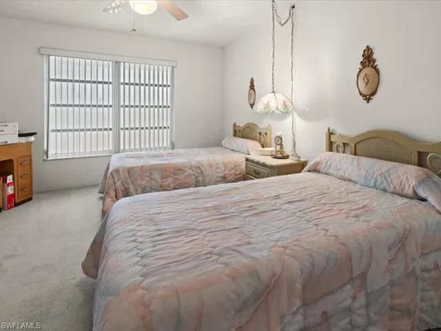 Carpeted bedroom featuring ceiling fan