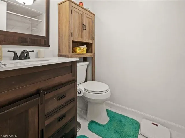Bathroom with tile patterned floors, walk in shower, vanity, and toilet