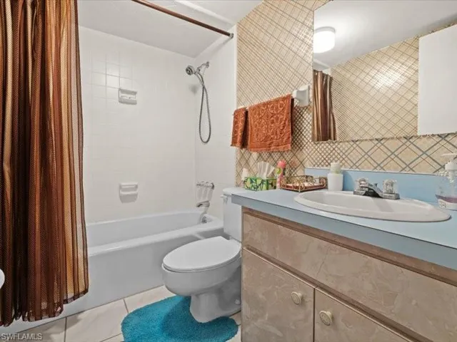 Full bathroom with shower / tub combo, vanity, and toilet