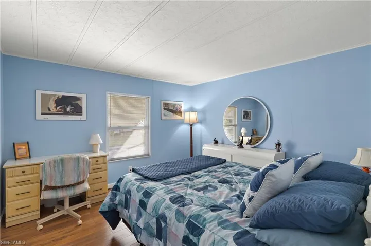 Bedroom with a textured ceiling and dark hardwood / wood-style floors