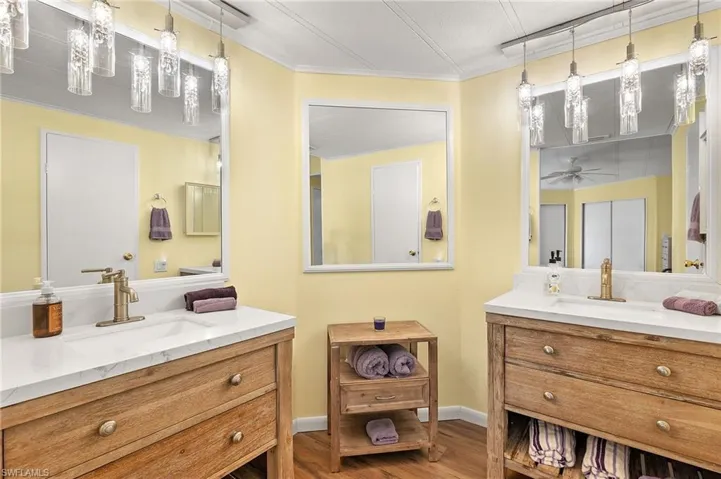 Bathroom featuring ceiling fan, hardwood / wood-style floors, vanity, and crown molding