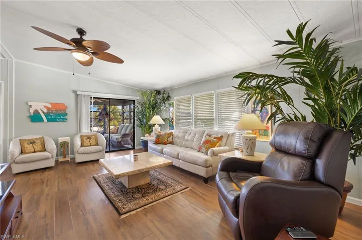 Living room featuring vaulted ceiling, ceiling fan, plenty of natural light, and dark hardwood / wood-style floors