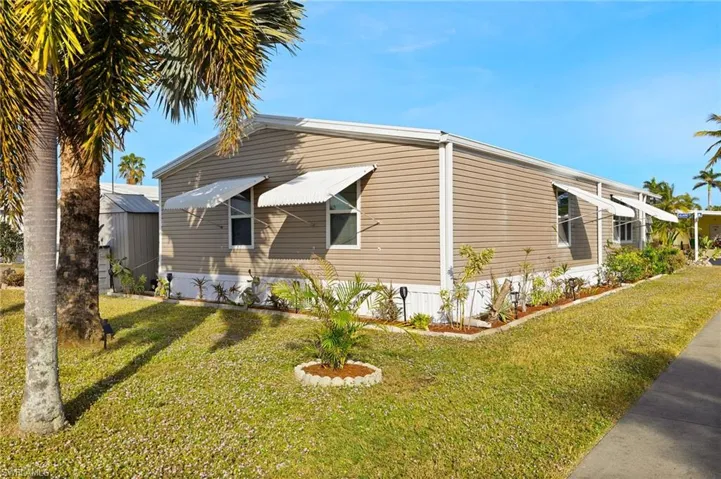 View of side of property with a lawn