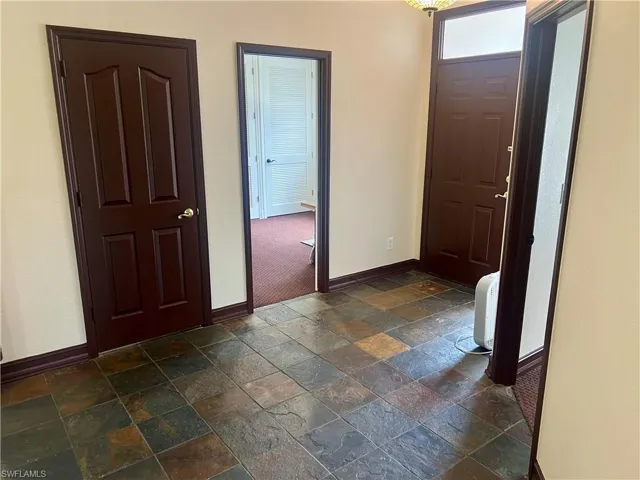 Entrance foyer featuring stone tile floors and baseboards