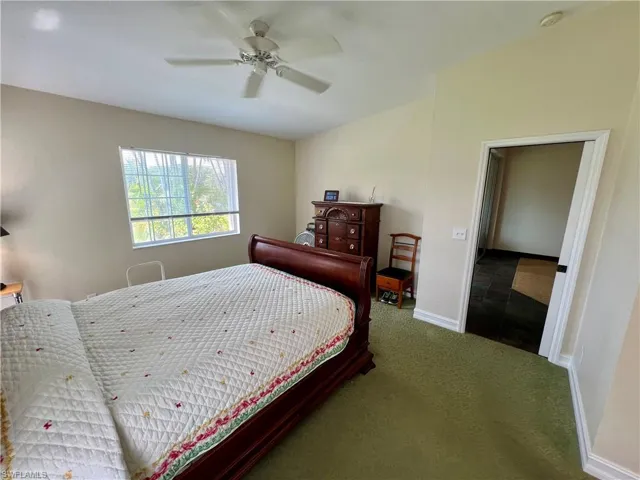 Bedroom featuring baseboards, a ceiling fan, and carpet flooring