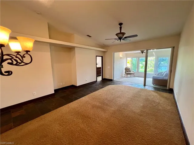 Spare room with baseboards, vaulted ceiling, visible vents, and a ceiling fan