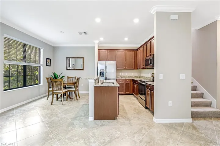 Kitchen featuring stainless steel appliances and granite countertops with easy access to stairs and second floor living area