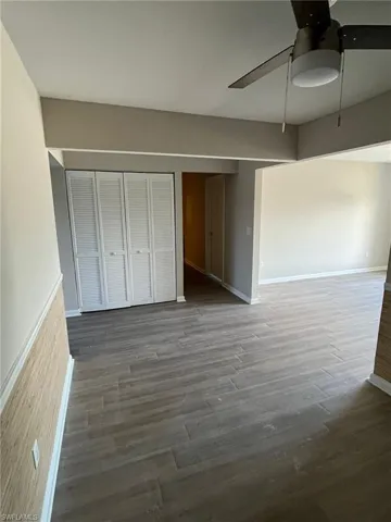 Unfurnished bedroom featuring baseboards, ceiling fan, and wood finished floors
