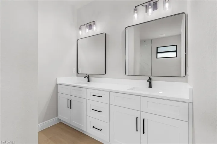 Bathroom with double vanity and wood finished floors