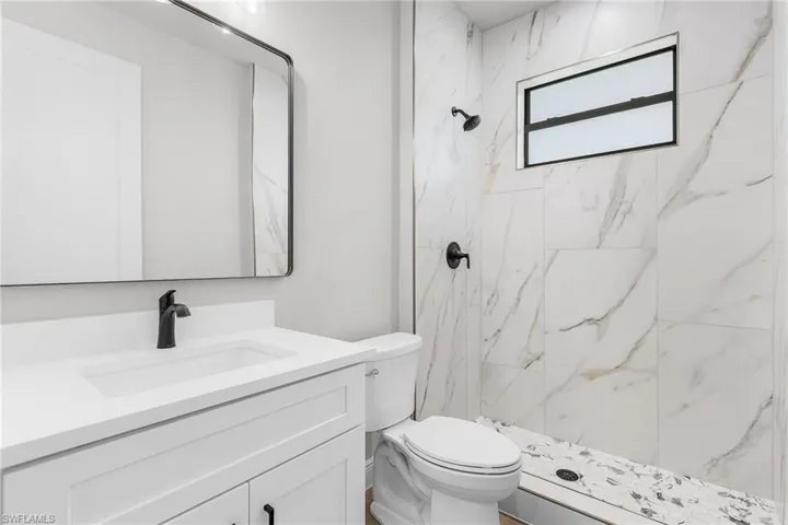 Full bathroom featuring vanity and a marble finish shower