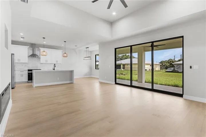 Unfurnished living room featuring a ceiling fan, light wood-style flooring, and recessed lighting