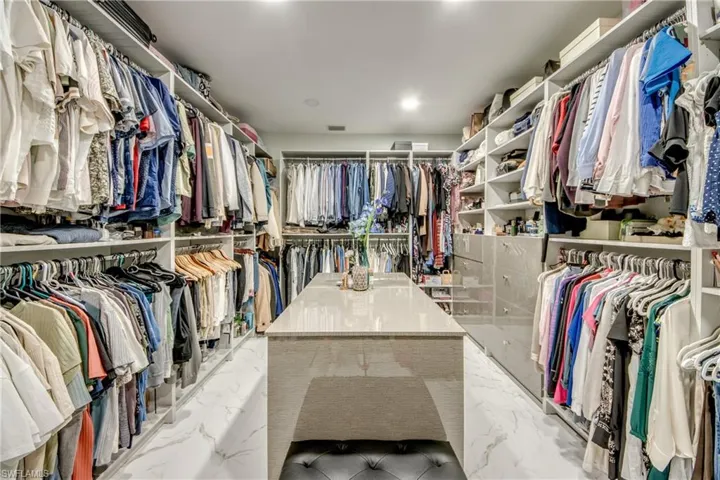 Walk in closet with light marble finish flooring