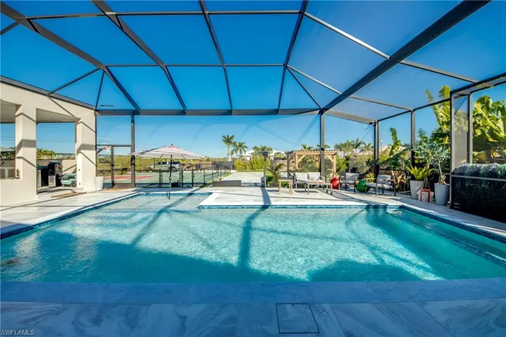 Swimming pool featuring a lanai, a patio, and a sunroom