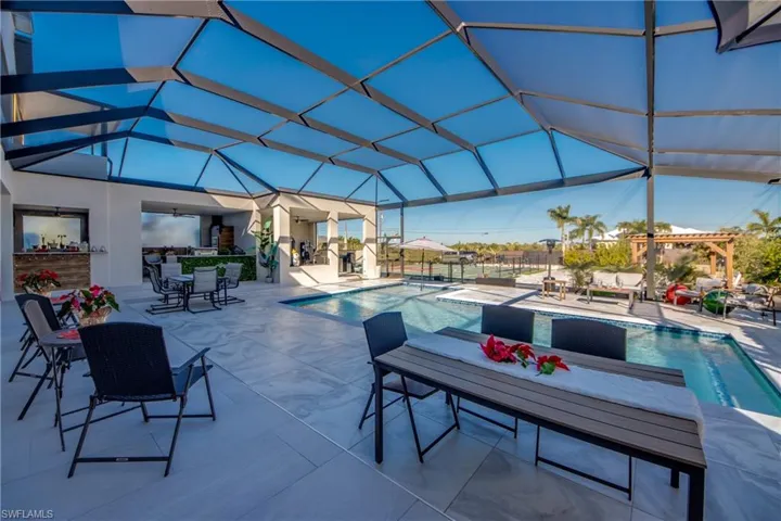 Outdoor pool with glass enclosure, a patio, and outdoor dining area