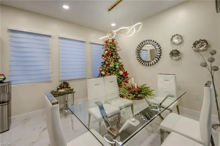Dining room with light marble finish flooring and recessed lighting