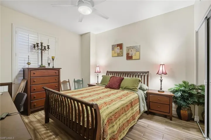 Bedroom with light wood finished floors, ceiling fan, and a closet