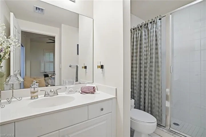 Full bathroom featuring a stall shower, vanity, and ensuite bath