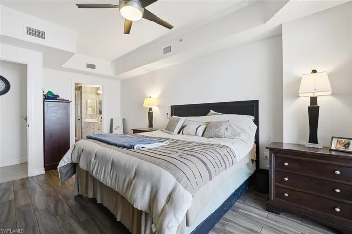 Bedroom with crown molding, wood tiled floors, ceiling fan, and ensuite bathroom