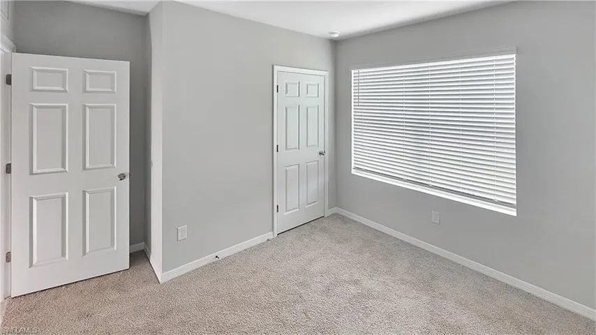 Unfurnished bedroom featuring light colored carpet