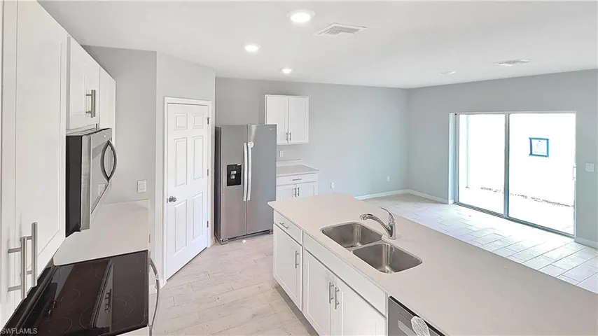 Kitchen with white cabinetry, sink, and stainless steel appliances