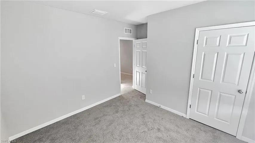 Unfurnished bedroom with light carpet