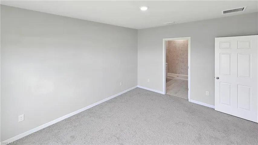 Unfurnished bedroom featuring carpet flooring and connected bathroom