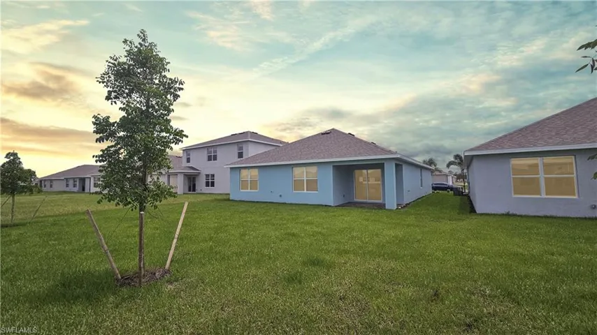 Back house at dusk with a yard