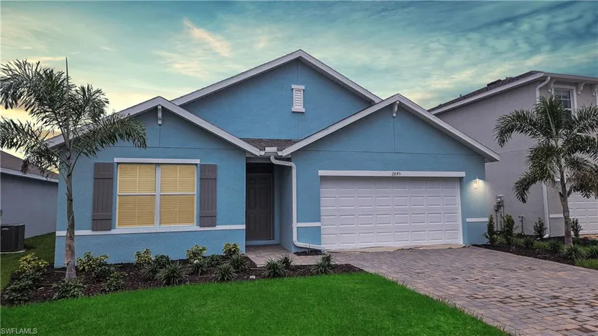 View of front of house with a garage, central AC, and a lawn