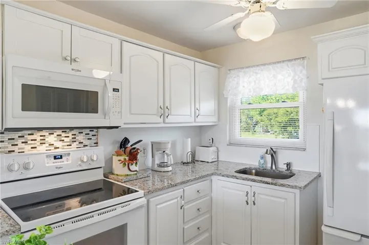 UPDATED KITCHEN WITH RAISED PANEL DOORS, GRANITE COUNTERS, AND NEWER WINDOW...