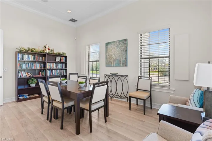 Dining area with light wood-type flooring, crown molding, and a wealth of natural light