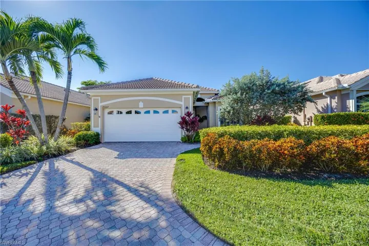 View of front of home featuring stucco siding, decorative driveway, a front lawn, a garage, and a tile roof