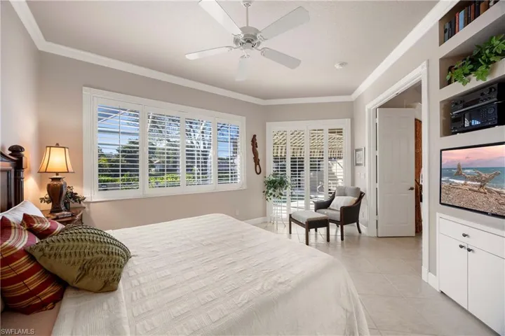Primary Bedroom with crown molding, access to exterior, light tile patterned floors, and ceiling fan