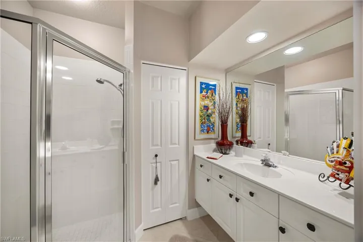 Guest bathroom with vanity, a stall shower, light tile patterned floors, and recessed lighting