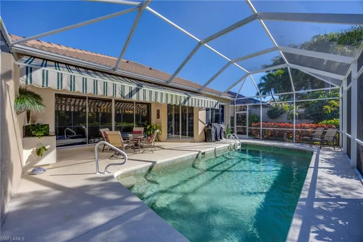 Outdoor pool, glass enclosure, a patio area, and grilling area