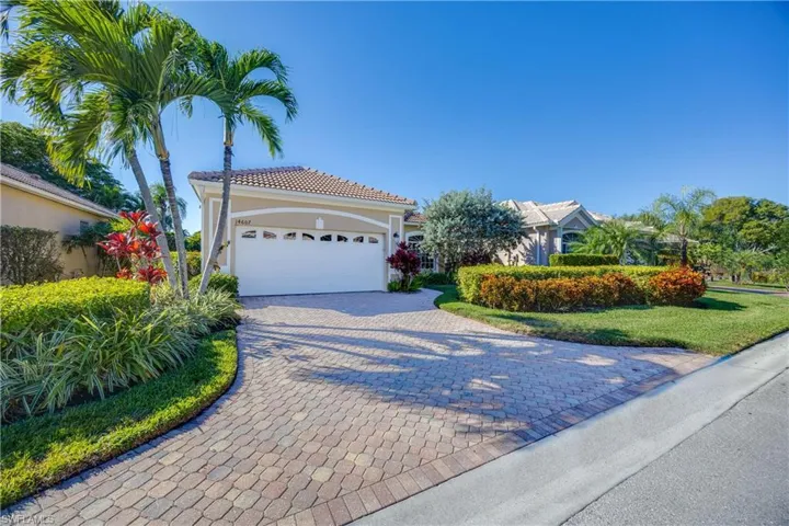 Mediterranean / spanish house featuring decorative driveway, stucco siding, a tile roof, an attached garage, and a front lawn