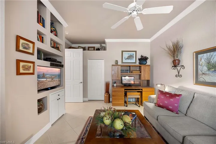 Bedroom used as a den featuring crown molding, light tile patterned floors, and a ceiling fan