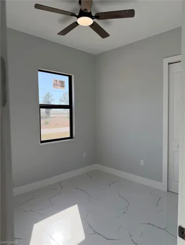 Empty room with marble finish flooring and ceiling fan