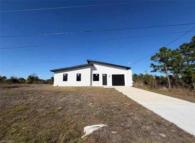 View of property exterior featuring stucco siding, driveway, and an attached garage