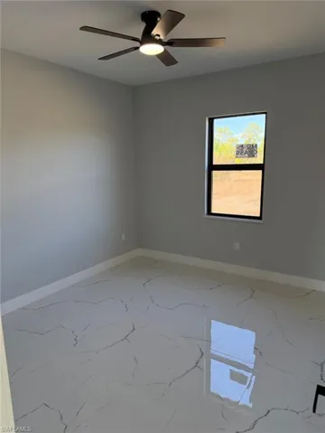Spare room featuring ceiling fan and light marble finish floors