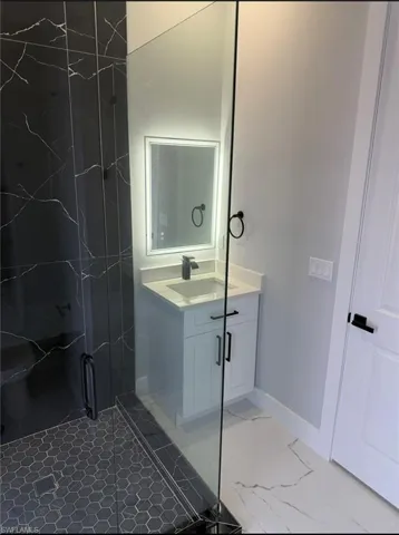 Bathroom with vanity and light marble finish floors