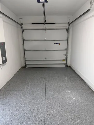 Garage featuring electric panel and a garage door opener