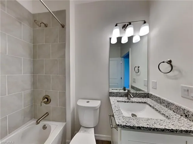 Picture of a previously completed home Bathroom featuring toilet, vanity, and shower / tub combination
