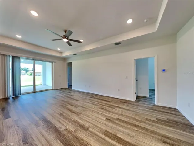 Picture of a previously completed home Spare room with a raised ceiling, ceiling fan, baseboards, wood finished floors, and recessed lighting