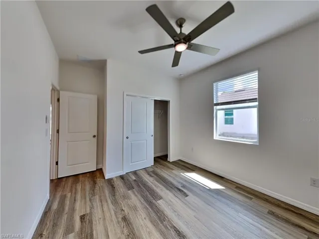 Picture of a previously completed home Unfurnished bedroom featuring wood finished floors, baseboards, a closet, and ceiling fan