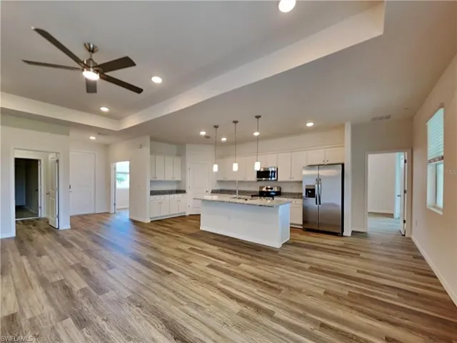 Picture of a previously completed home Kitchen featuring appliances with stainless steel finishes, ceiling fan, open floor plan, light wood-style flooring, and recessed lighting